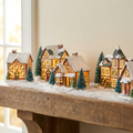 Evergreen Lit Christmas Village Set glowing on a snowy styled mantel