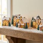 Evergreen Lit Christmas Village Set glowing on a snowy styled mantel
