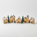 Lighted ceramic Christmas village houses on a white studio background