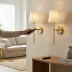 Hand using the remote to adjust a Lyra wall sconce in a hallway