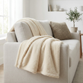 Cloudsoft cream plush fleece throw blanket draped over a modern sofa